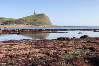 A view across Kimmeridge Bay towards Clavell Tower at low tide