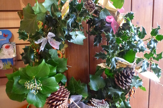 A festive Christmas wreath made from natural materials hanging on a door