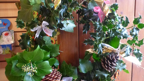 A festive Christmas wreath made from natural materials hanging on a door